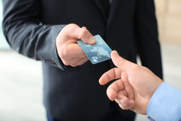 Zakenman die creditcard geeft aan mensenclose-up