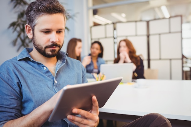 Zakenman die digitale tablet gebruiken tegen vrouwelijke medewerkers