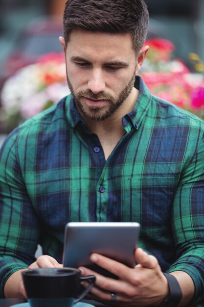 Foto zakenman die digitale tablet gebruiken terwijl het hebben van koffie