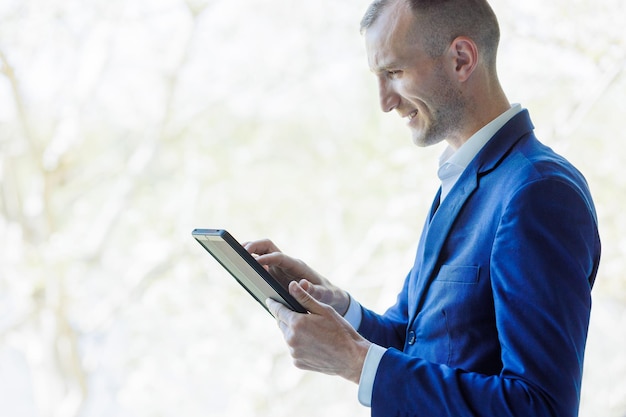 Zakenman die een bedrijf beheert vanaf een digitale tablet Knappe ondernemer die zaken doet