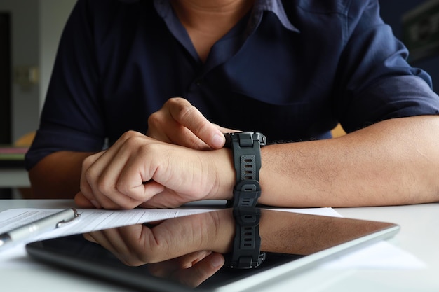 Zakenman die een digitaal slim horloge in de hand draagt en het scherm aanraakt om het gelezen bericht te openen