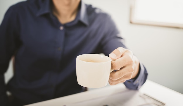 Zakenman die een kopje koffie drinkt en aan laptop werkt verkoopbeheer