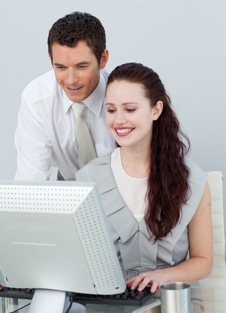Zakenman die een onderneemster met een computer helpt