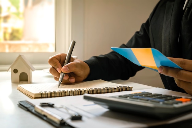 Zakenman die een pen gebruikt om financiële rapporten te schrijven Voorbereiding van financiële overzichten