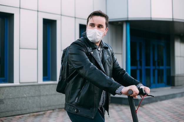 Zakenman die elektrische autoped gebruikt die hygiënisch masker draagt om besmetting te verhinderen