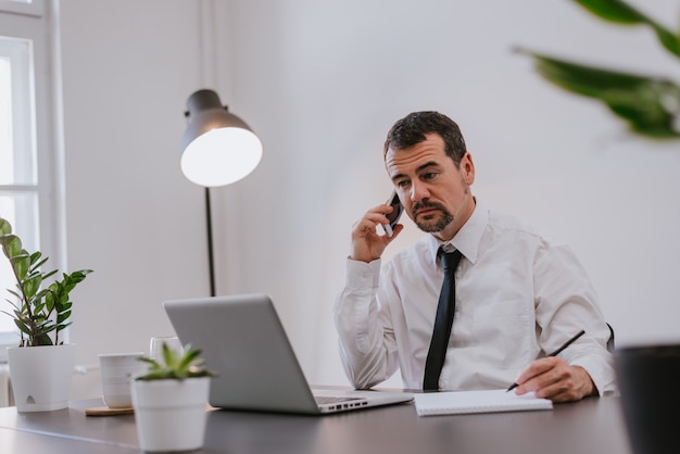 Foto zakenman die in bureau op telefoon spreekt