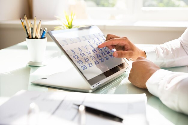 Foto zakenman die kalender op laptop gebruikt