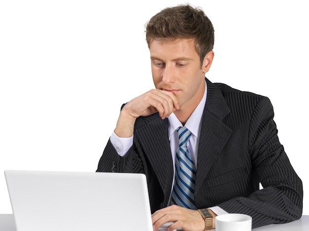 Zakenman die laptop gebruikt terwijl hij op kantoor zit