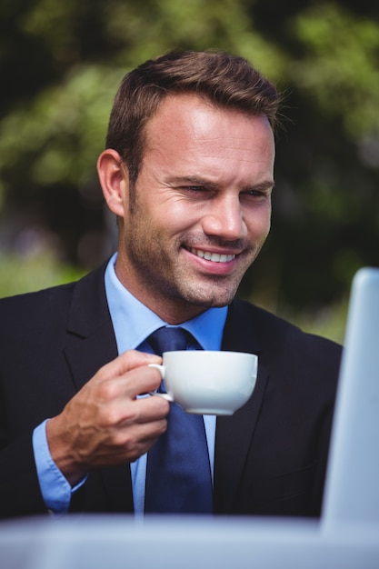 Zakenman die laptop met behulp van en een koffie heeft