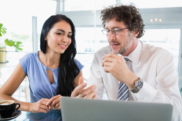 Zakenman die met collega over laptop bespreekt