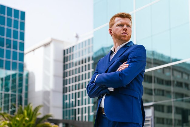 zakenman die met gekruiste armen poseert in een modern kantoorcomplex