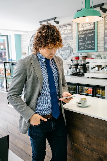 Zakenman die mobiel in een café kijkt