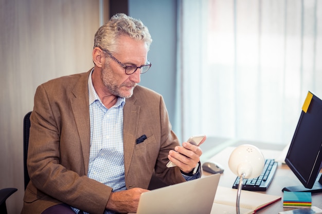 Zakenman die mobiele telefoon met behulp van