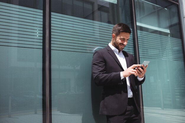 Zakenman die mobiele telefoon met behulp van