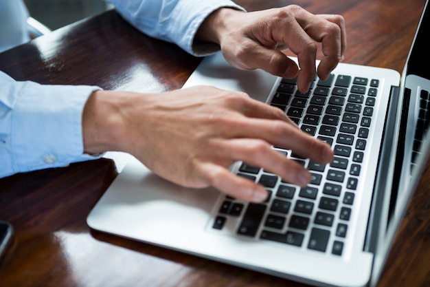 Zakenman die op laptop op bureau werkt