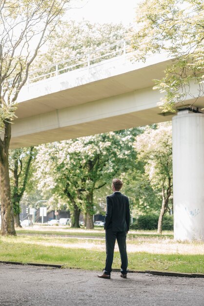 Foto zakenman die zich buiten bij een brug bevindt