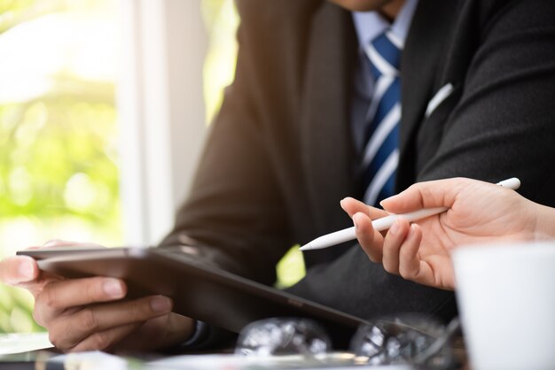 Zakenman en onderneemster die tabletvergadering gebruiken. Zakelijke bijeenkomst discussie.