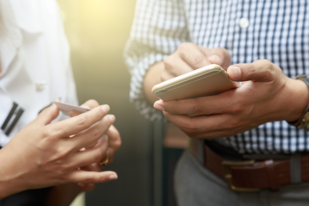 Zakenman en vrouw die over bedrijfsinformatie over telefoon bespreken en contact ruilen