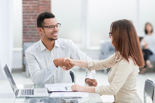 Zakenman en zakenvrouw maken een deal in een modern kantoor