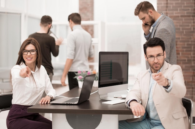 Zakenman en zakenvrouw zitten aan de balie en wijzend op youbusiness concept