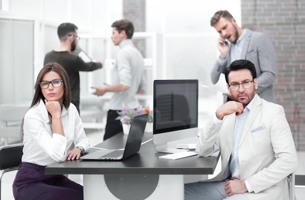 Zakenman en zakenvrouw zitten aan het bureau