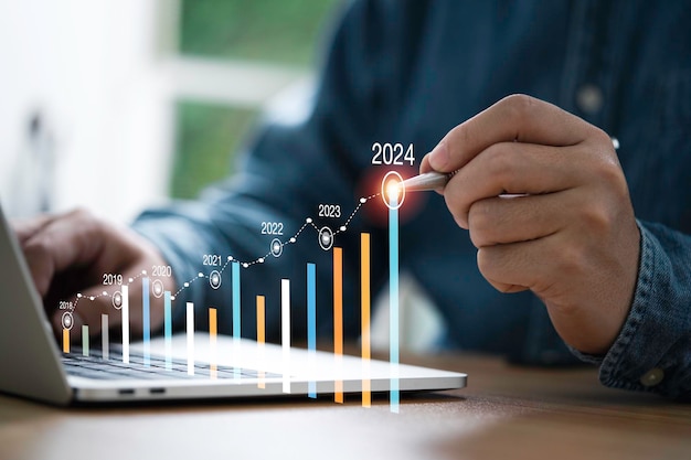 Zakenman gebruikt elektronische pen schrijven stijgende kleurrijke grafiek van 2023 tot 2024 jaar van business schaven en voorraad investeringen groei concept
