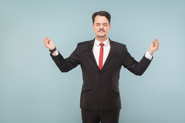 Zakenman gesloten ogen staan en doen yoga pose