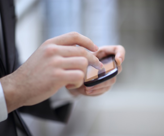 Zakenman hand gebruik telefoon, close-up van een man met behulp van mobiele slimme telefoon achtergrond.