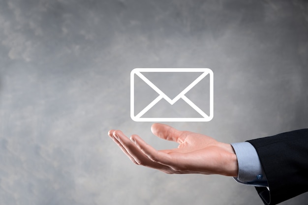 Zakenman hand met e-mailpictogram, neem contact met ons op via nieuwsbrief e-mail en bescherm uw persoonlijke gegevens tegen spam-mail. Klantenservice callcenter contact met ons concept.