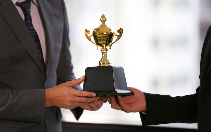 Foto zakenman hand met gouden trofee, zakelijke winnaar award.