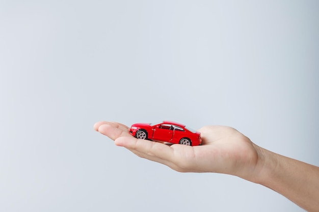 Zakenman hand met rode auto speelgoed Auto verzekering garantie verhuur Financieel nieuw en reparatie concept