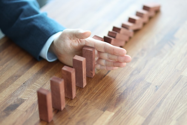 Zakenman hand scheidt houten blokken op tafel