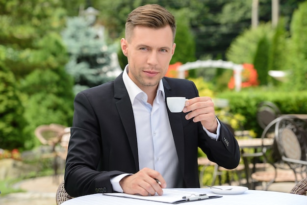 Zakenman het drinken koffie terwijl het zitten in een koffie.