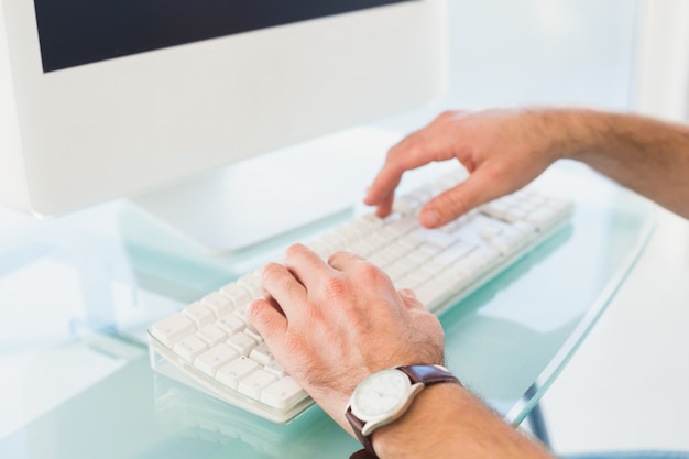 Zakenman het typen op computertoetsenbord in zijn bureau