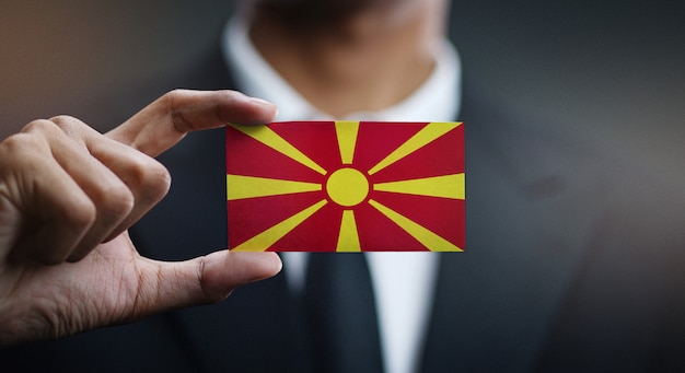 Foto zakenman holding card van de republiek macedonië vlag