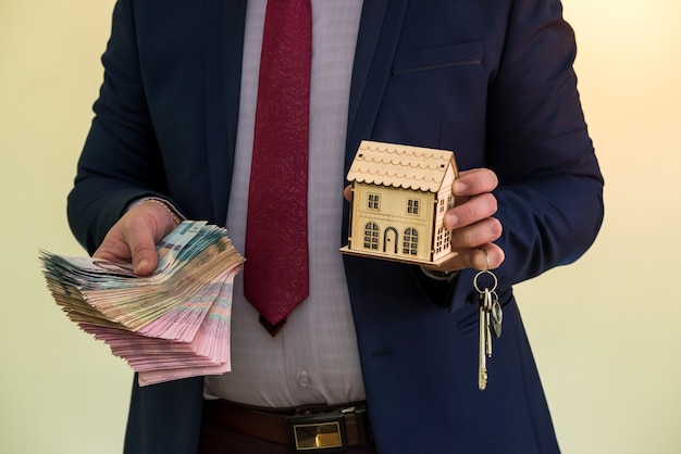 Zakenman houdt de sleutels van het appartement met iemands geld na verkoop of verhuur van een huis. het aangaan van een succesvolle overeenkomst