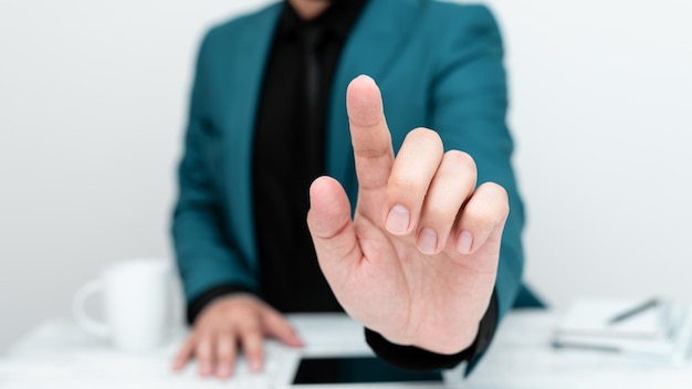 Zakenman in blauw jasje zittend aan tafel en wijzend met één vinger op belangrijk bericht Gentleman kritische aankondiging telefoon op tafel tonen