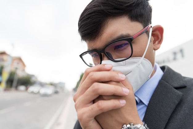 Zakenman in een pak dragen van beschermende gezichtsmasker en hoest