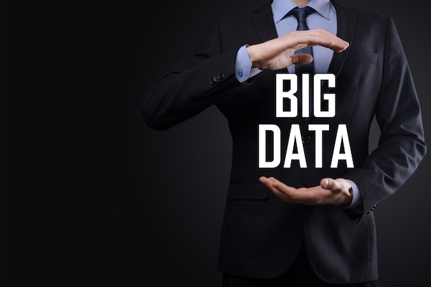 Zakenman in een pak op een donkere achtergrond heeft het opschrift BIG DATA. Opslag netwerk Online Server Concept.Social netwerk of business analytics vertegenwoordiging.