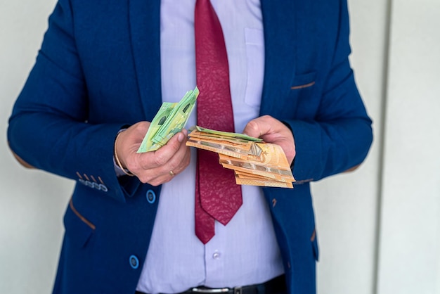 Zakenman in een pak telt eurobankbiljetten, loon- of salarisconcept