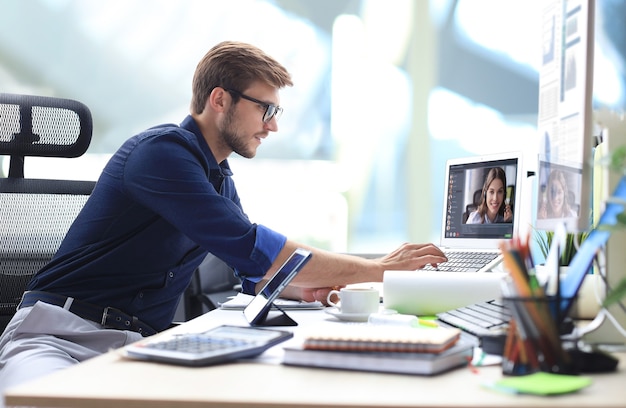 Zakenman in koptelefoon praten met zijn collega's in videoconferentie