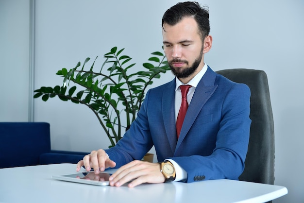 Zakenman in pak met behulp van digitale tabletcomputer op kantoor