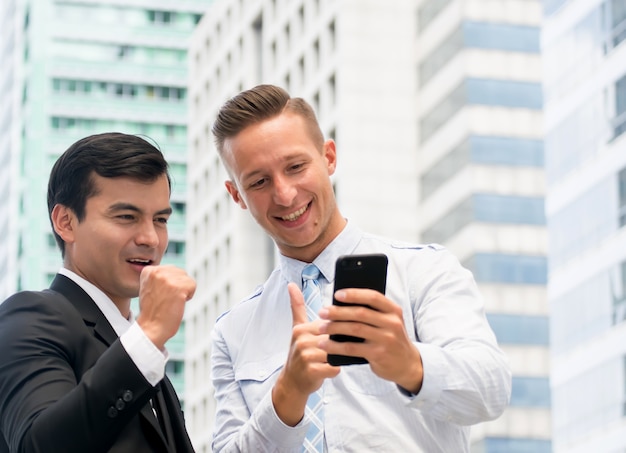 Zakenman in slimme casual met behulp van mobiele telefoon met bouw achtergrond