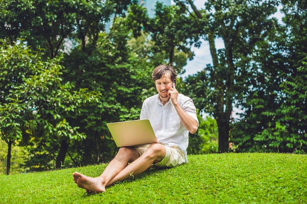 Zakenman in vrijetijdskleding met laptop in park