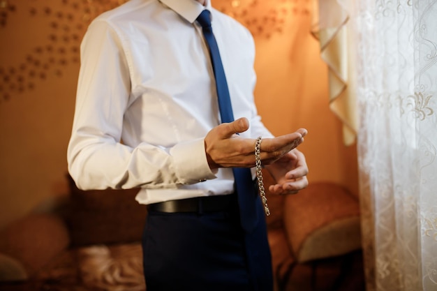 Zakenman in wit overhemd armband bij de hand zetten Man mode
