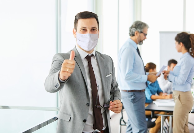 Zakenman kantoor portret zakelijke vergadering bescherming duim omhoog man zakelijke masker virus corona-epidemie