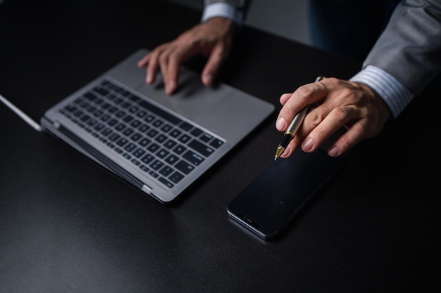 Zakenman kijken naar financiële informatie van een mobiele telefoon hij controleert de financiële documenten van het bedrijf hij is een directeur van een startend bedrijf Concept van financieel beheer