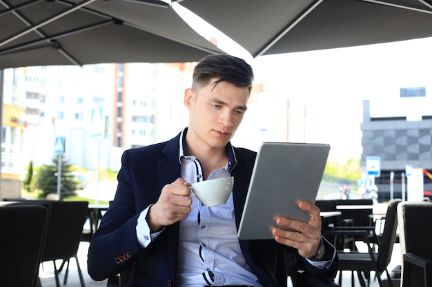 Zakenman koffie drinken en nieuws lezen in café.