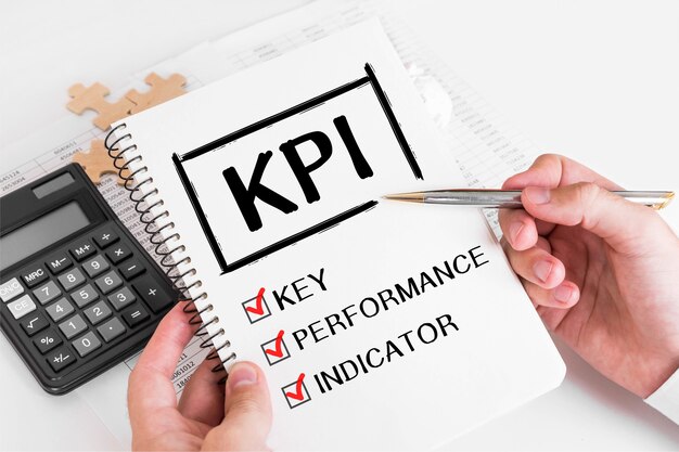 Zakenman KPI-concepten op zijn notitie schrijven.