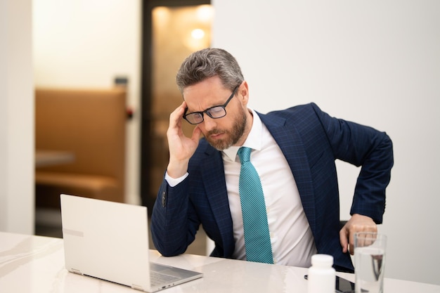 Zakenman kreeg migraine raakt haar hoofd vanwege pijn man manager met sterke hoofdpijn aan het werk